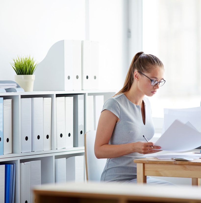 Young accountant looking through papers at workplace
